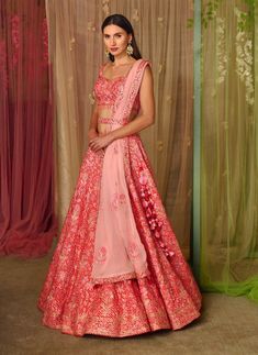 Editor's Note This set features a lehenga with thread and gota embroidered on printed silk with belt and embroidered organza dupatta Color: Pink Fabric: Silk, organza Sleeve: Sleeveless Neckline: Sweetheart Embroidery details: Gota and thread embroidery Component: Blouse, lehenga, belt and dupatta Lehenga length: 43" inches and blouse: 14" inches Occasion: Sangeet Care: Dry clean only About the Designer Shyam Narayan Prasad started his journey in the Indian Fashion Design Industry with a couture Pink Silk Sharara With Floral Embroidery, Pink Raw Silk Set With Floral Embroidery, Pink Organza Sets For Navratri, Pink Organza Lehenga For Navratri, Pink Organza Lehenga With Zari Work, Pink Organza Choli For Navratri, Pink Bollywood Sets In Organza, Pink Sharara With Floral Embroidery In Tissue Silk, Pink Tissue Silk Sharara With Floral Embroidery