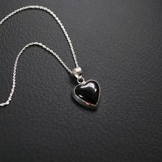 Elevate your jewelry collection with the timeless elegance of our 15mm Onyx Heart Pendant. Expertly crafted from premium 925 sterling silver, this exquisite pendant features a stunning onyx gemstone, intricately cut into a beautiful heart shape. The perfect blend of sophistication and charm, this pendant is a wonderful symbol of love and style. * Material: High-quality 925 sterling silver, renowned for its durability and lustrous finish. * Gemstone: Genuine Black onyx, providing a striking and e Pendant Heart, Silver Heart Pendant, Onyx Gemstone, Necklace Black, Beautiful Heart, Black Heart, Love Symbols, Heart Pendant Necklace, Silver Heart