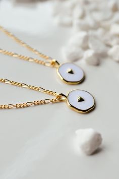 This is a new favorite minimal charm necklace. It's SO pretty. White charm with a gold heart in the middle, and it's hanging from our logan chain. Layer this up with a Luna necklace and you've got a really beautiful stack. Gold-filled is the closest alternative to solid gold. Gold filled jewelry has a thick layer of solid gold bonded onto the base layer, usually brass or sterling silver. Compared to gold plated which uses a process of electroplating that quickly dips your jewelry in gold, result White Clavicle Chain Necklace For Valentine's Day, Dainty Heart Charm Necklace For Best Friend Gift, Dainty Heart Charm Necklace For Best Friend, Heart Charm Jewelry For Best Friend Gift, White Necklace With Round Pendant And Cable Chain, White Round Pendant Necklace With Cable Chain, Dainty Heart Pendant Charm Necklace For Best Friend, Dainty Heart Pendant Necklace For Best Friend, Heart Charm Pendant Necklace For Everyday