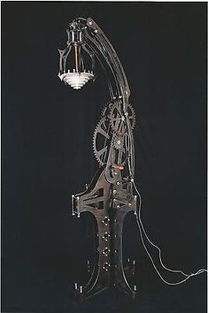 an old clock with gears attached to it's sides and two lights on each side