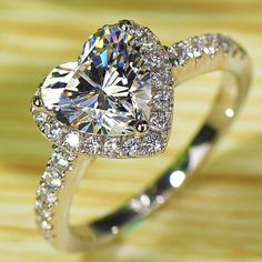 an engagement ring with a heart shaped diamond in the center