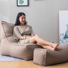 a woman sitting on a bean bag chair in a living room with her legs crossed