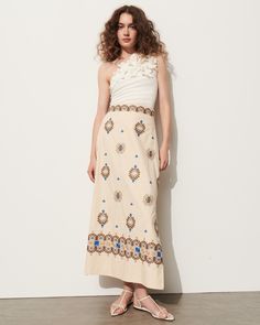 This soft a-line skirt is intricately embroidered in bold blue, rich tan, and soft sand coloring detailing a floral-inspired motif. Complement the high-rise waist with the matching top or a flowy t-shirt. Side-zip closure Length from Highest Point to Hem: 36 1/2" Detailed embroidery throughout Side slits Cotton Poplin Floral Embroidered Flared Dress, Spring Beige Long Skirt Dress, Spring Beige Dress With Long Skirt, Spring Floral Embroidered Flared Skirt Dress, Spring Embroidered Beige Skirt, Spring Flared Dress With Floral Embroidery, Spring Floral Embroidered Flared Dress, Spring Dress With Floral Embroidery And Flared Skirt, Elegant Summer Skirt With Floral Embroidery