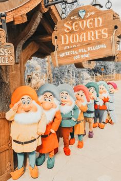 seven dwarfs are lined up in front of the sign for seven dwarfs at universal studios