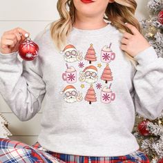 Get into the holiday spirit with our Groovy Santa Pink Christmas and Holiday Drink T-Shirt, Sweatshirt, or Hoodie. Featuring a groovy Santa and festive holiday drink design, this top is perfect for adding some fun to your wardrobe. Available in three styles - t-shirt, sweatshirt or hoodie - you can choose the fit that suits you best. Spread some cheer this season with our Groovy Santa Pink Christmas and Holiday Drink top. Key Features: - Festive Groovy Santa design - Fun holiday drink graphic - Available in t-shirt, sweatshirt or hoodie styles  Whether you're looking for a cozy sweatshirt to snuggle up in on cold winter nights or a casual t-shirt that expresses your festive spirit at any time of day, we've got you covered. The pink color adds an extra touch of whimsy to this jolly design. Cozy Winter Holiday Sweatshirt, Casual Long Sleeve Hoodie For Holiday, Casual Long Sleeve Holiday Hoodie, Casual Long Sleeve Holiday Sweatshirt, Casual Christmas Hoodie With Crew Neck, Casual Holiday Hoodie With Crew Neck, Casual Crew Neck Hoodie For Holiday, Casual Cozy Christmas Top, Festive Cozy Crew Neck Sweater