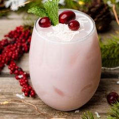 a drink in a glass with cherries on the rim and garnishes