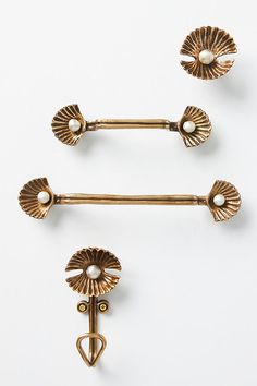 two antique gold door handles with pearls on each one and a heart shaped finial