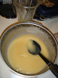 a mixing bowl filled with yellow liquid next to a blender