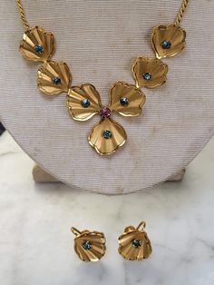 Vintage 1940s Bugbee Niles choker and screwback earrings set. Goldtone blue rhinestones with a center pink rhinestone.  Nice condition.  Any questions or concerns please ask.  See photos for measurements.  Check out my other etsy shop Arlettemichelle just put my shop name in the etsy search bar all one word.  My sons art Jmoriginalart.com 40s Necklace, 1930’s Jewelry, 1940s Necklace Vintage, 1960s Sounthern Vintage Earrings Jewelry, Vintage Rhinestone Adjustable Necklace, Pink Rhinestones, Blue Rhinestones, Screw Back Earrings, Baskets On Wall