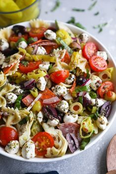 a white bowl filled with pasta salad and vegetables