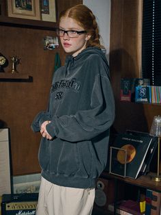 a woman standing in front of a bookshelf with her hands on her hips