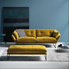 a living room with blue walls and yellow furniture