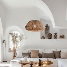 a living room filled with white furniture and lots of pillows on top of the couch