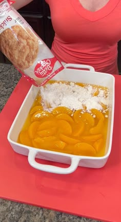 a woman pours orange juice into a dish with bread crumbs on top