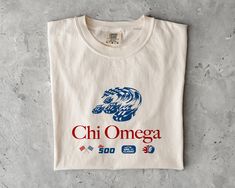 a white t - shirt with the words chi omega printed in red and blue