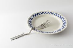 a fork in a blue and white plate with a chain