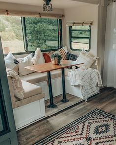 a living area with couches, table and rugs in front of the window