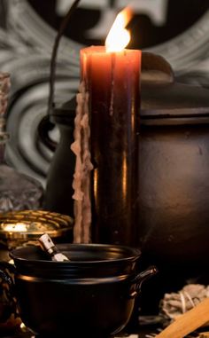 a lit candle sitting on top of a table next to other items and decorating