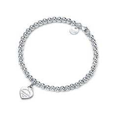 Inspired by the iconic key ring first introduced in 1969, the Return to Tiffany collection is a classic reinvented. An elegant bead bracelet and engraved tag combine to create a simple and timeless design. Sterling silver tag on a bead bracelet; Size medium, 7" long; Beads, 4 mm | Return To Tiffany® Heart Tag Bead Bracelet in Silver, Size: 7 in. Tiffany Bead Bracelet, Tiffany And Co Bracelet, Tiffany Bracelets, Return To Tiffany, Bracelet In Silver, Bracelets Design, Bracelet Love, Estilo Boho Chic, Heart Tag