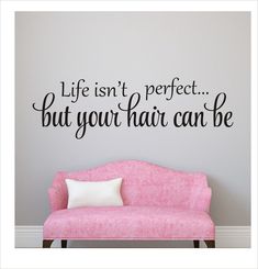 a pink couch sitting in front of a wall that says life isn't perfect but your hair can be