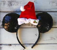 a mickey mouse ears hat on top of a white wooden surface with blue and gold flowers