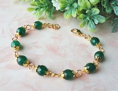 "This exquisite bracelet features green jade gemstone. Each flanked with decorative bead-caps plated in 24 karat gold. The piece is finished with a decorative toggle closure and has my signature logo tag. The bracelet is adjustable from 7\" to 8\" and is finished with a secure gold lobster claw clasp. Also available in sterling silver plate." Gold And Jade Bracelet, Jade And Gold Bracelet, Emerald Bracelet Gold, Green Beaded Bracelets, Cluster Bracelets, Emerald Bracelet, Bracelets Design, 24 Karat Gold, Jade Gemstone