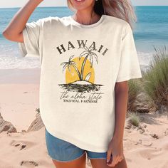 Escape to paradise with our Hawaii Tropical Paradise Comfort Color Tee! Made with ultra-soft fabric, this tee will provide comfort while also giving off a tropical vibe. Perfect for any casual occasion, this tee is sure to become your go-to choice. Aloha, comfort, and style all in one! Design is Printed Direct to Garment. See Size Guide for Comfort Color Unisex Tee Casual Crew Neck T-shirt For Vacation, Cotton T-shirt With Tropical Print, Spring Crew Neck T-shirt With Palm Tree Print, Cotton Tropical Print T-shirt, Spring Tropical Print Graphic Tee, Spring Palm Tree Print Short Sleeve T-shirt, White Tropical Print T-shirt For Vacation, Tropical Cotton T-shirt With Palm Tree Print, Spring Graphic Tee With Tropical Print