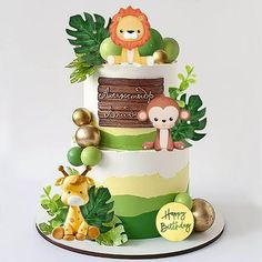 a three tiered cake decorated with jungle animals