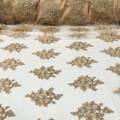 the bed is covered with gold embroidered fabric