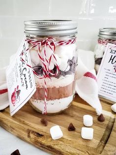 two mason jars filled with marshmallows on a cutting board next to each other