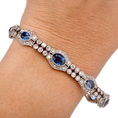 Walser Wald Vintage Deco Diamond Sapphire Platinum Bracelet Presenting a gorgeous Vintage Art Deco Bracelet crafted in Platinum with Natural Diamonds and Sapphires. In a two-row Oval link Design the gemstone and Diamonds are bezel and Prong set to perfection.  It is secured with an Insert clasp and a chain with a spring ring. Diamond total Carat weight approx: 5.70 cttw Clarity Grade approx: F-G Color Grade approx: VS2-SI1 Set with nine bezel-set sapphires, weighing approx: 14.50  cttw Bracelet Elegant Multi-stone Oval Tennis Bracelet, Elegant Oval Multi-stone Tennis Bracelet, Elegant Multi-stone Platinum Jewelry, Elegant Multi-stone Diamond Bracelet, Luxury Multi-stone Diamond Bracelet For Formal Occasions, Elegant Multi-stone Sapphire Bracelet, Elegant Sapphire Multi-stone Bracelet, Elegant Diamond Multi-stone Bracelets, Elegant Multi-stone Diamond Bracelets