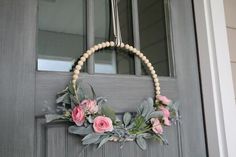 a wreath with flowers hanging on the front door