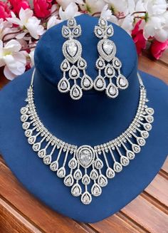 Add a touch of glamour and sophistication with this high quality necklace set in beautiful clear stones. The stones in this set bling and look close to the real thing. This set is sure to make heads turn!  It features an adjustable necklace and a pair of earrings. It can be paired perfectly with both ethnic and western outfits.  In case of any queries, please feel free to reach out. Happy shopping! Hand-set Silver Bridal Sets In Cubic Zirconia, Silver Bridal Sets With Hand Set Cubic Zirconia, Silver Bridal Sets With Hand-set Cubic Zirconia, Silver Cubic Zirconia Bridal Sets With Elegant Design, Silver Diamond Bridal Set With Sparkling Stones, Silver Bridal Set With Rhinestones And Cubic Zirconia, Dazzling Silver Bridal Sets With Elegant Design, Elegant Silver Cubic Zirconia Bridal Sets, Dazzling Silver Bridal Sets