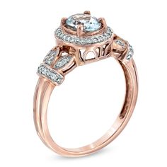 Honor her with a gift of elegance and beauty. This vintage-inspired gemstone ring is certain to capture her heart. Designed in precious 10k rose gold, this ring features a 7.0 x 5.0mm ice-blue oval-shaped aquamarine center stone surrounded by a halo of glittering diamonds. Intricate scroll work below the bezel enhances the ring's luxurious look while sparkling diamond accents form crowns on the shank, flanking the center arrangement and completing the style. Radiant with 1/6 ct. t.w. of diamonds, this ring is polished to a bright shine. Vine Ring, Diamond Frame, Scroll Work, Peoples Jewellers, Diamond Glitter, Sparkling Diamond, Aqua Marine, Aquamarine Rings, Sparkle Diamonds