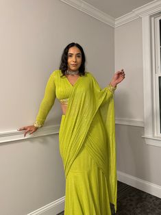 This Charlie Pre-Draped Saree comes in a lovely bratty green apple color and features a hand-embroidered and hand-pleated blouse with intricate sequins. With hooks and handmade hangings on the back, the blouse offers a secure and well-fitted appearance with the added convenience of cups. The pre-draped design allows for easy wearing in just 1 minute, without any hassle. It can be delivered in 2-3 weeks and can be customized in the desired color and sleeve length upon request. Fabric: Crepe with Blouse Hangings, Draped Saree, Shirt Jacket Men, Drape Saree, Apple Coloring, Designer Drapes, Pleated Blouse, Silk Roses, Crepe Fabric