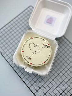 an open take out container with a heart on it and the lid is white in color