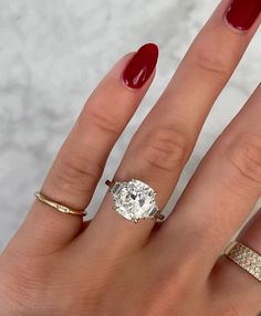 a woman's hand with three different rings on it and a ring in the middle