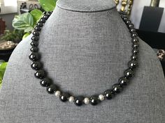 This choker necklace is substantial.  It is simple, classic and unique.   It has a matching bracelet. Both items are made with `12mm gunmetal hematite beads with pearl spacer beads.  It has a sweetheart lobster claw closure. The hematite stone is believed to dissolve negativity and prevents you from absorbing the negativity of others. Quality and durability are very important in handcrafting my designs.  I strive to make exceptional jewelry designs for all of my clients that will last for years. If you are not completely satisfied with your purchase, please let me know. Please visit my shop at etsy.com/shop/simplyunikcreations for other unique findings.   Thank you. Silver Hematite Necklace With 8mm Beads, Silver Magnetic Jewelry With Round Beads, Magnetic Silver Jewelry With Round Beads, Hematite Necklace, Necklace And Bracelet Set, Hematite Stone, Necklace And Bracelet, Matching Bracelet, Hematite Beads