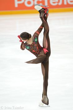 a female figure skating on an ice rink