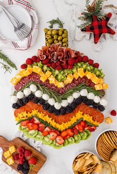 a platter filled with fruit and veggies on top of a white counter