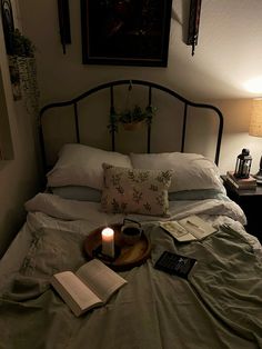 a lit candle on a bed with an open book