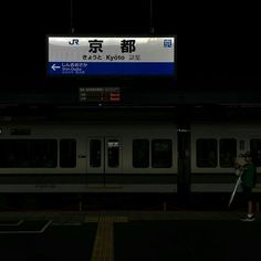 a subway train at night with people standing on the platform