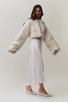 Introducing our new Alyana Faux Fur Jacket, the perfect topper for your favorite dress. This ultra-soft, plush coat adds a touch of glam to any outfit while keeping you warm and stylish. Its cropped length is designed to flatter, making it the ideal piece to throw on for a night out or a special occasion. Fabrication: Luxe Faux Fur; 100% Polyester Sonali is wearing a size S and is 5'10" with a 31" bust, 35" hips, and 23" waist White Dress With Fur Coat, Fur Jacket Over Dress, Winter Bachelorette Outfit For Bride, Elegant Winter White Fur Coat With Faux Fur Lining, Elegant Long Sleeve Fur Coat With Faux Fur Lining, Winter Courthouse Wedding Outfit, Elegant Winter White Faux Fur Coat, Luxury Faux Fur Spring Coat, Evening Faux Fur Coat For Fall