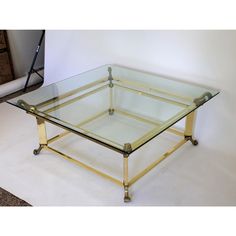 a glass and metal coffee table on wheels