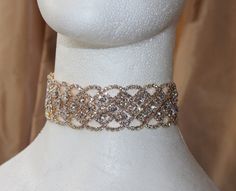 Stunning choker with a beautiful shine. The choker has a long extension so you can be adjusted to fit perfectly around your neck. Give your outfit a little sparkle with this perfect trading choker. This rhinestone choker comes in gold as shown, rose gold, gold ab silver, and black diamond.  This listing is for 1 piece This rhinestone trim is 1 1/4'' wide and 10'' long with a 5'' extension. Item ships in 3-5 business days. If you have any questions please let us know we are here to help. Thank yo Glamorous Gold Choker For Evening, Glamorous Gold Choker For Wedding, Adjustable Gold Rhinestone Necklace For Wedding, Gold Rhinestone Choker For Party, Gold Crystal Embellished Choker Necklace, Adjustable Sparkly Rhinestone Necklace For Weddings, Adjustable Sparkling Rhinestone Necklace For Wedding, Gold Bridal Choker Necklace For Party, Glamorous Gold Bridal Necklace With Rhinestones