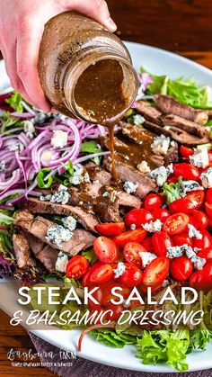 steak salad and balsamic dressing being drizzled over it on a white plate