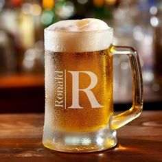 a beer mug sitting on top of a wooden table with the letter r in it