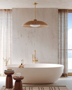 a large white bath tub sitting in a bathroom next to a tall window with curtains