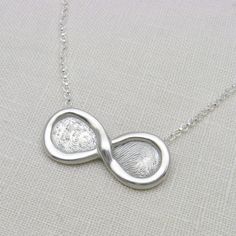 "Custom Personalized Silver Fingerprint Infinity Necklace or Pendant - This beautiful necklace is personalized with your ACTUAL fingerprints and is a beautiful wedding gift, anniversary gift, best friend gift, Mother's Day gift, and more! Handmade using fine silver, the pendant measures approx. 5/8\" x 1-3/8\" and hangs on a sterling silver rolo chain that closes with a silver lobster clasp. I will add a small layer to the back with a date or initials, which is textured with tiny hearts. If you Elegant Customized Necklaces For Anniversary Gift, Elegant Customizable Necklace For Anniversary Gift, Elegant Customized Necklace For Anniversary Gift, Elegant Customizable Necklace For Anniversary, Customized White Gold Necklace For Anniversary, Elegant Customized Silver Necklace, Elegant Silver Custom Necklace, Elegant Hand Stamped Pendant Jewelry, Infinity Necklaces For Wedding On Mother's Day