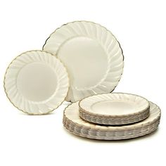 a set of four white plates with gold rims